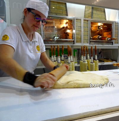 Bäckerin rollt Hefetig für Baumkuchen