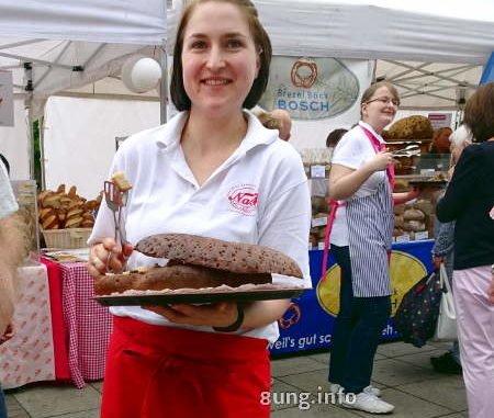 bäckereifachverkäuferin bietet Brot zum Probieren an