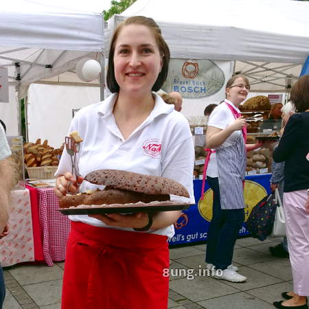 bäckereifachverkäuferin bietet Brot zum Probieren an