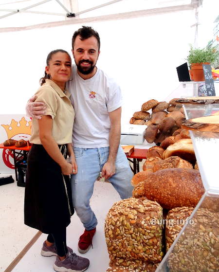 großer Bäcker und kleine Verkäuferin am Brotstand