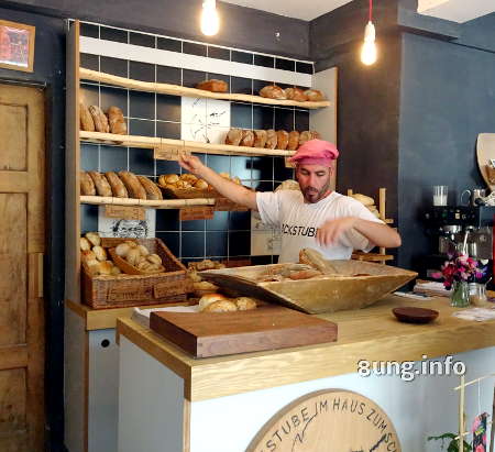 Bäcker sortiert sein Brot im Laden ins Regal