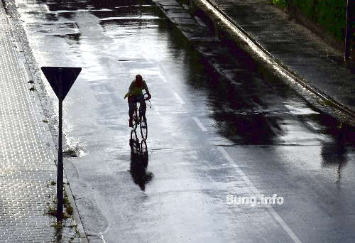 Radfahrer im Regen, die Sonne im Rücken