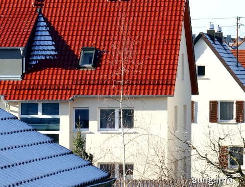 Schnee im Schatten auf roten Dächern