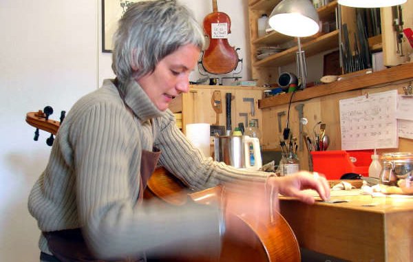Geigenbaumeisterin bei der Arbeit an einem Cello