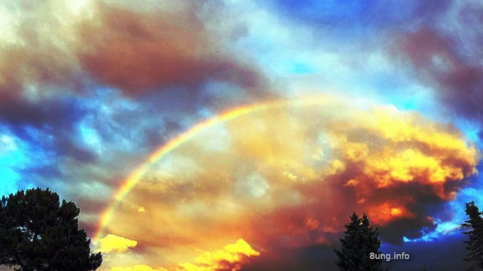 Feuriger Regenbogen vor blauem Himmel