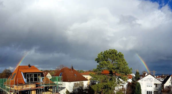 Regenbogen, von grauen Wolken verdeckt