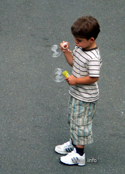 Kind mit Seifenblasen, ins Spiel vertieft