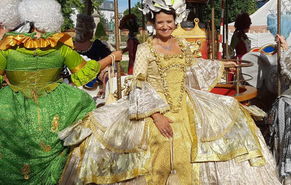 Dame in goldenem Rokokokleid auf einem Karussell