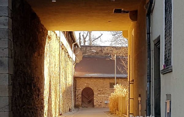 Blick durch den Torbogen in den sonnigen Hof