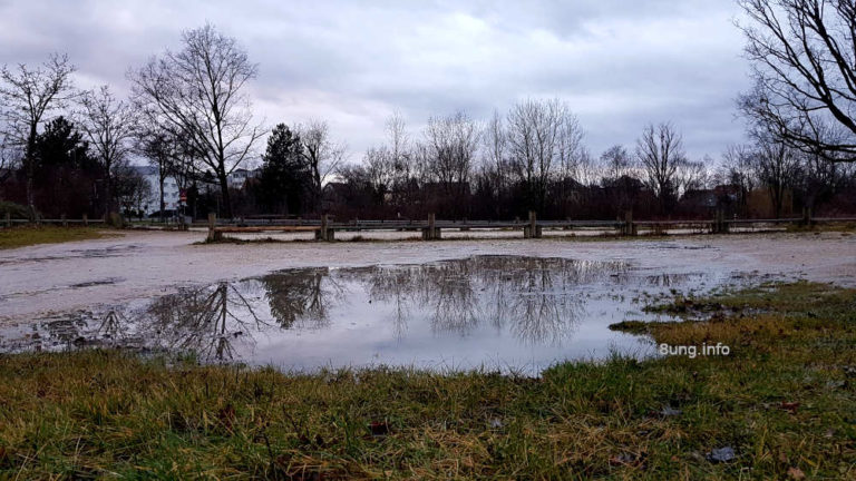 Riesenpfütze auf einem verwaisten Schwimmbadparkplatz