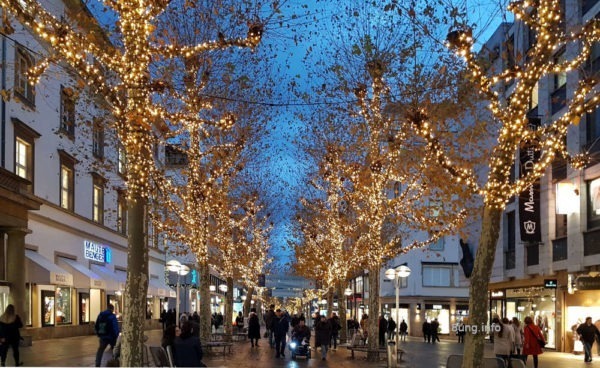 Königsstrasse mit Lichterketten in den Bäumen in der Dämmerung