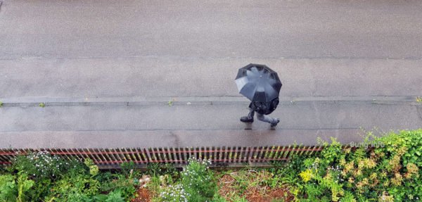 Fussgänger mit schwarzem Regenschirm