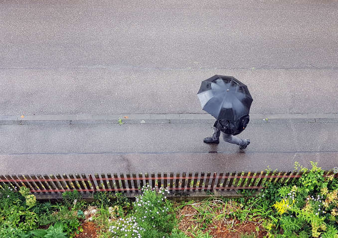 Fussgänger mit schwarzem Regenschirm