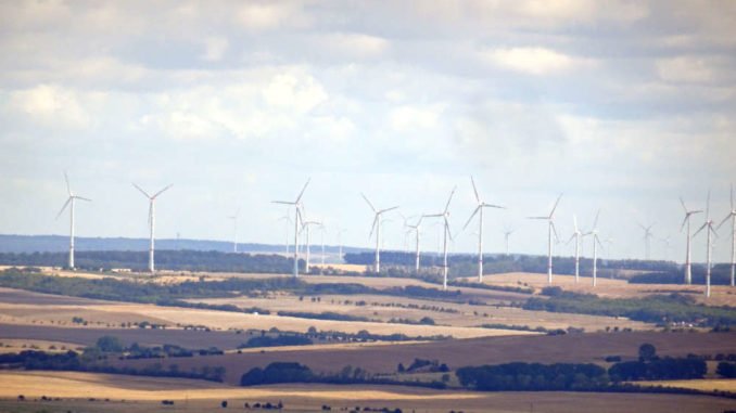 Blick auf Büsche, Felder und Windräder