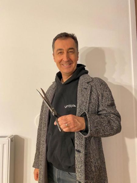 Cem Özdemir mit Mantel und Schneiderschere