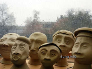 Regentropfen auf der Fensterscheibe, Keramikköpfe im Vordergrund