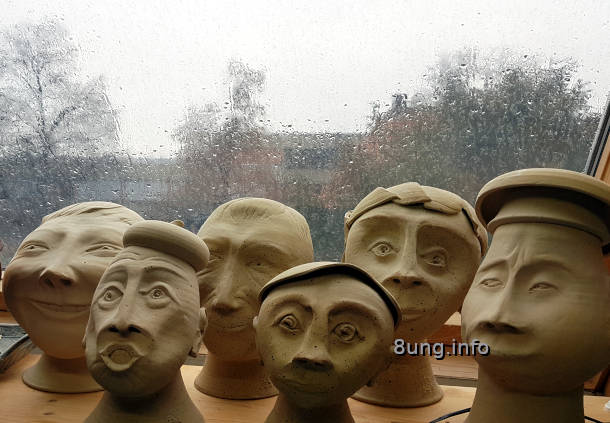 Regentropfen auf der Fensterscheibe, Keramikköpfe im Vordergrund
