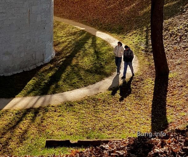 Spaziergänger und Bäume im Gegenlicht