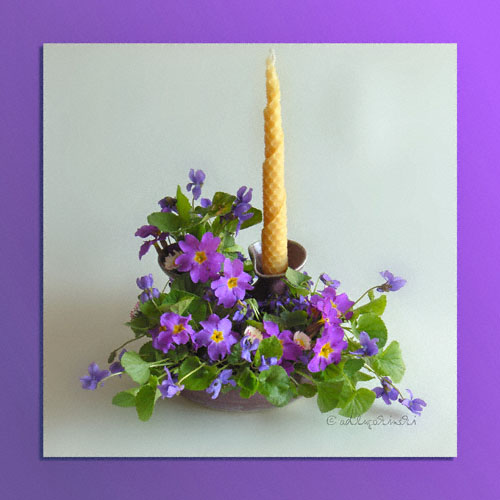 Blumengesteck mit Veilchen, Primeln und Kerze