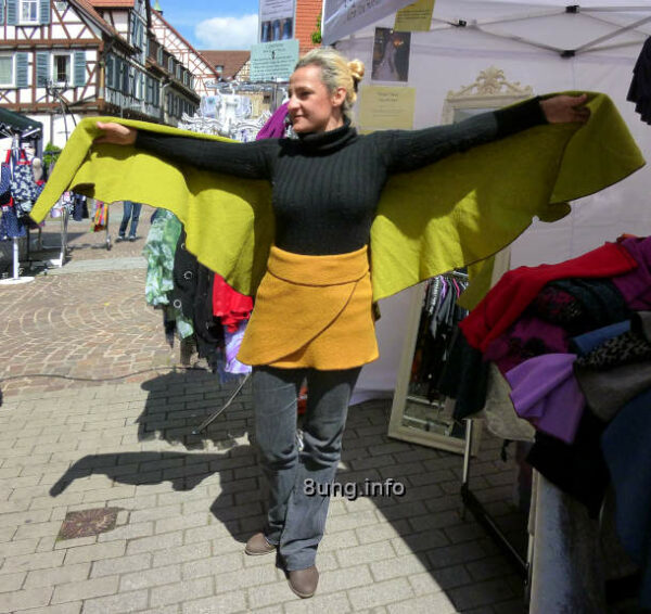 Wetter an Eisheiligen: Junge Frau mit Poncho, Arme ausgebreitet