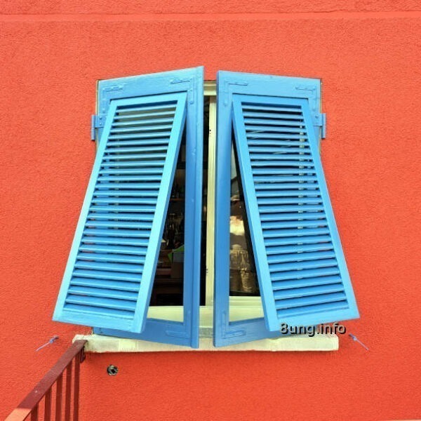 Blaue Fensterläden vor einer roten Wand