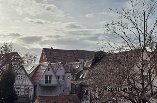 Häuser mit Spitzgiebeln vor grauen Wolken