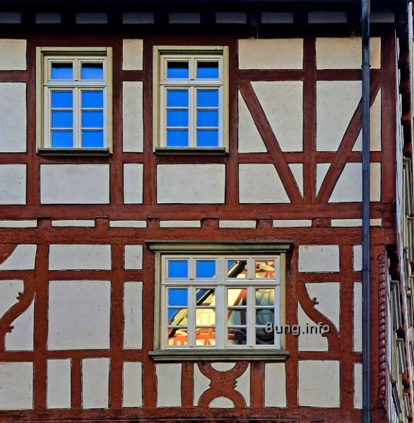 Fachwerkhaus mit Spiegelung von Himmel und Nachbarhaus im Fenster