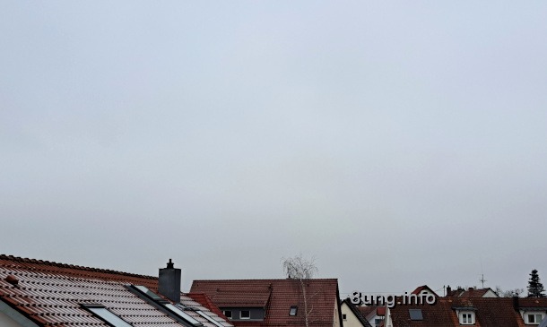 einheitlich grauer Himmel über roten Ziegeldächern