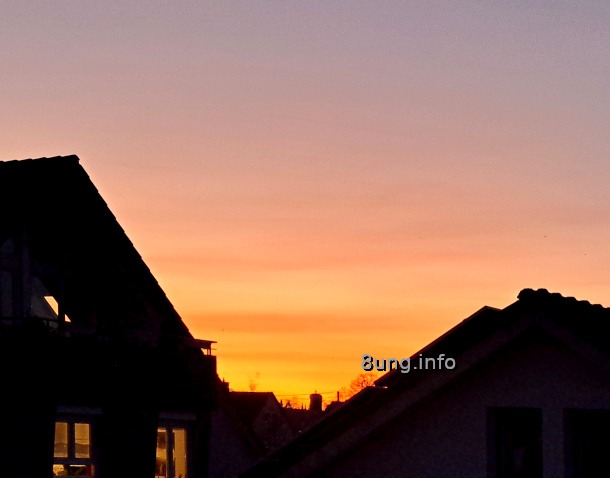 untergehende Sonne, roter Himmel zwischen 2 Häusern