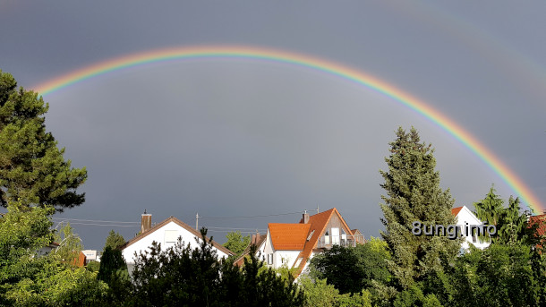 Regenbogen mit dunklen Wolken im Hintergrund