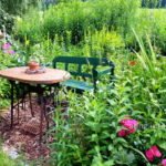 Nähmaschinentisch mit grüner Sitzbank im Garten